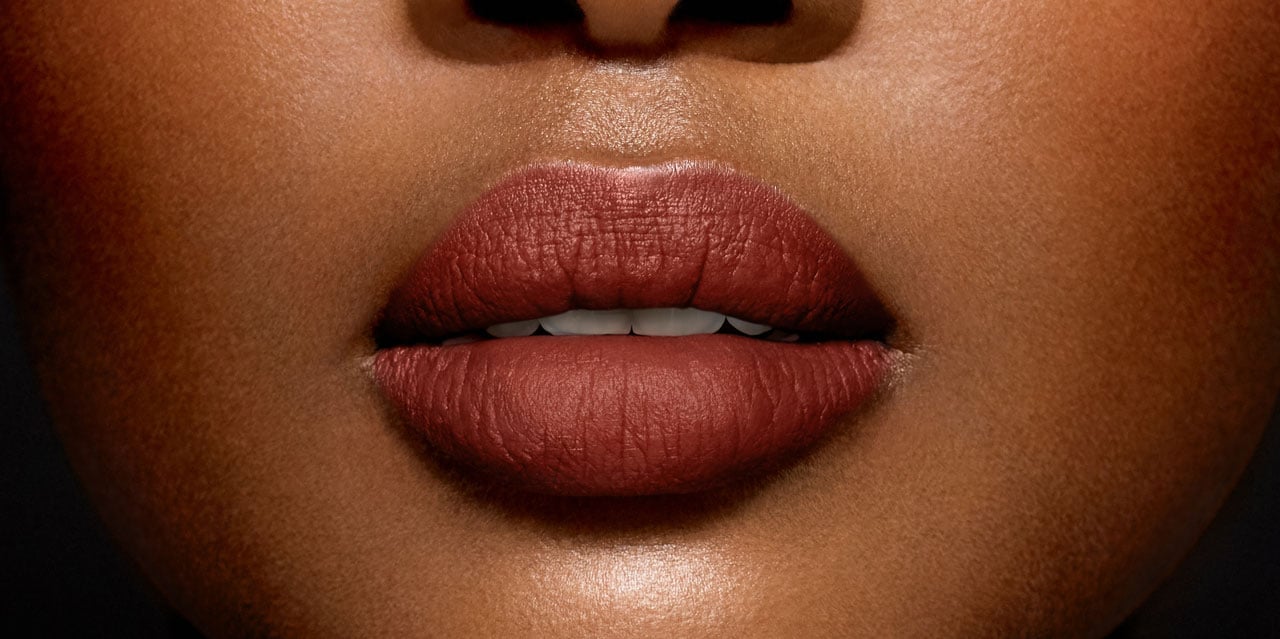 Warm toasted caramel brown lipstick shade worn on a dark skin tone